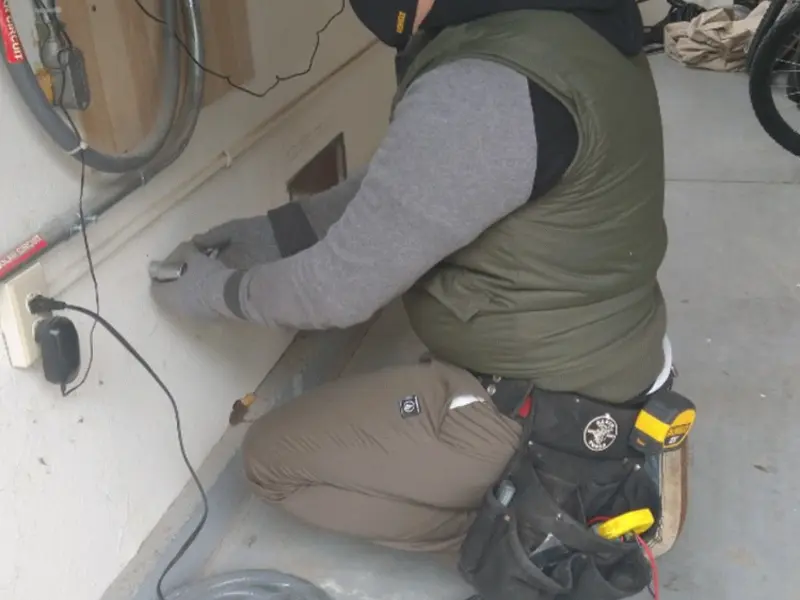 Electrician performing outlet wiring in a Burrillville garage